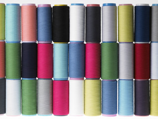 Colors, colorful spools of thread on a white background