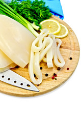 Squid with lemon and knife on a round board