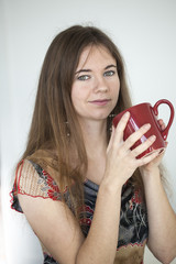 Young Woman with Beautiful Green Eyes with Red Coffee Cup