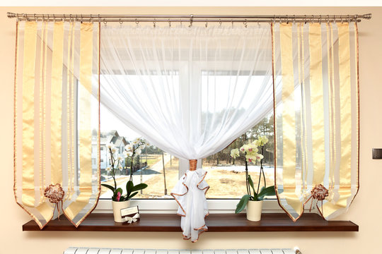 Okno w salonie, zasłona i kaloryfer.