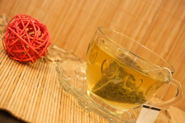 Glass cup with fresh green tea on a bamboo napkin