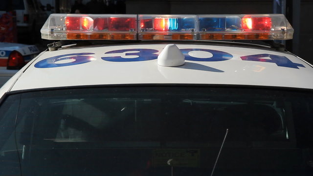 Toronto police car and flashing lights. Handheld shot.