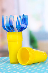 Cups, spoons and forks, of different colors on bright