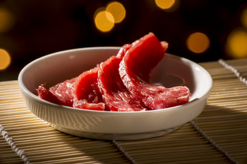 Sliced raw meat in white bowl