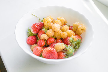 Assorted berries in bowl on white background