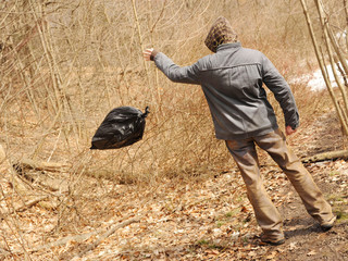 Neglectful man throwing out the garbage in the forest