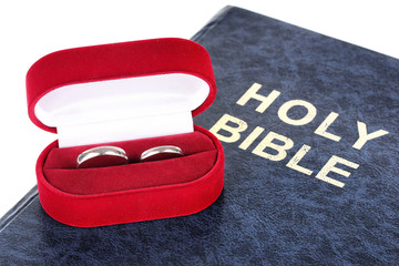 Wedding rings on bible isolated on white