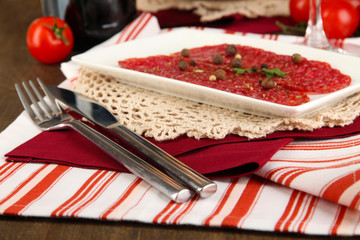 Tasty salami on plates on wooden table close-up