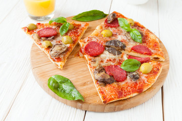mouthwatering pizza with salami, cut into pieces