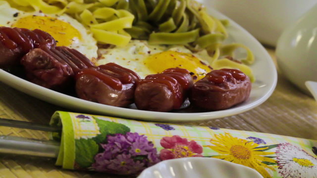 Fried eggs with macaronis and sausages