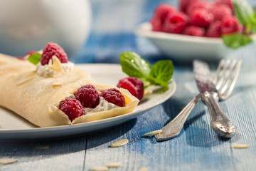 Closeup of pancakes with raspberry and whipped cream