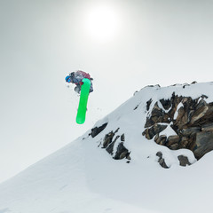 Snowboarder jumping in mountains