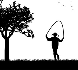A little girl playing skipping rope in park in spring silhouette