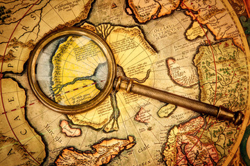 Vintage magnifying glass lies on the ancient map of the North Po