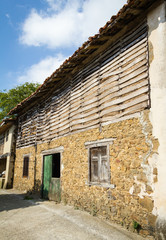 Fototapeta na wymiar Barn with straw stored behind a wooden fence