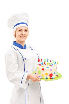 Female chef holding a birthday cake