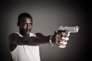 Naklejka na ściany i meble Killer with gun close up over dark background. Focus on gun.