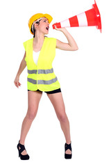 Attractive female construction worker shouting into traffic cone