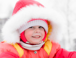 Beautiful happy kid in the red warm clothing