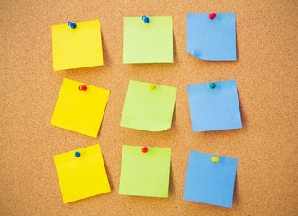 Colour note papers on pin board. Cork background