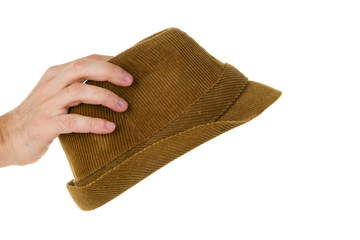 Hand holds old brown hat isolated on white background