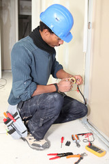 Electrician taping a wire
