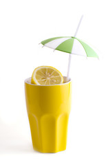 Slices of lemon in yellow ceramic cup with a straw
