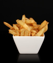 French fries in bowl isolated on black