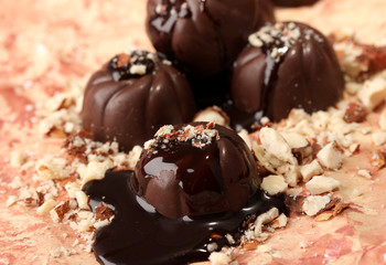 Chocolate candies with nuts, on color background