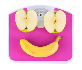 Apple and banana on scales isolated on white