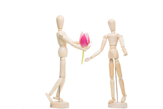 wooden little man giving flower on the isolated white