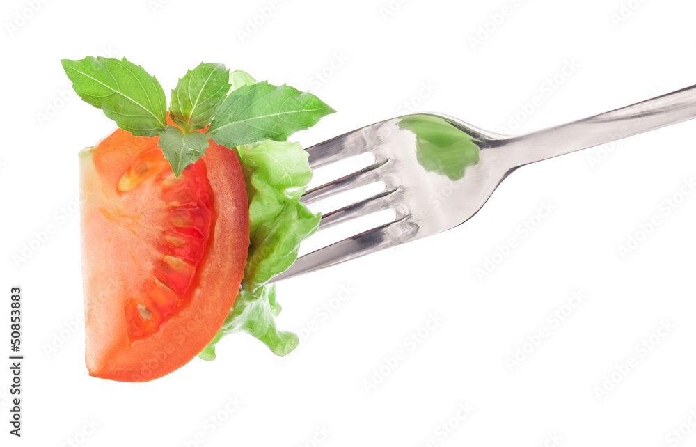 Wall mural tomato slice, basil and lettuce on fork isolated on white