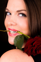 You beautiful female with a rose in her mouth - obrazy, fototapety, plakaty