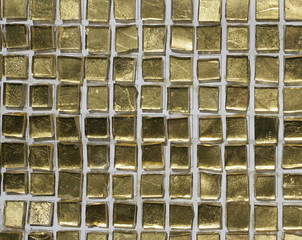 Goldene Mosaiksteinchen, angeordnet auf einer Wand