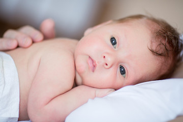 newborn baby boy lying on mother's breast