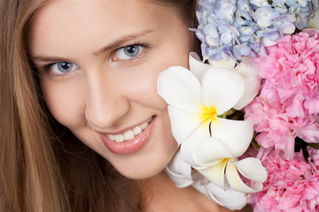 Obraz na płótnie Canvas Portret atrakcyjne kaukaski uśmiechnięta kobieta z kwiatami