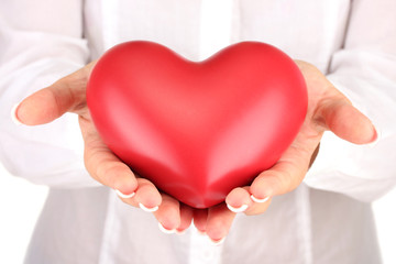 Red heart in woman's hands, on white background close-up