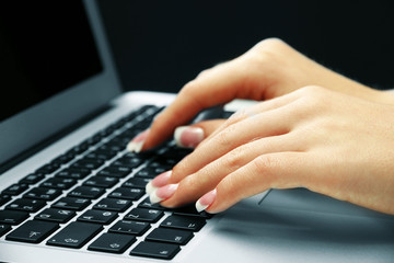 Female hands typing on laptot, close-up