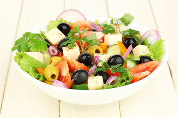 Fresh salad in plate on wooden table