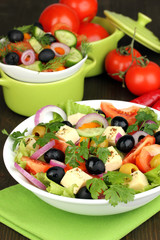 Greek salad in plate on wooden table