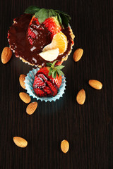 Fruit in chocolate against a dark background