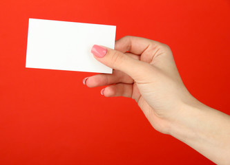 Obraz premium Female hand holding business card, on color background