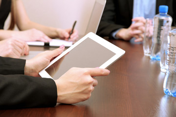 Female hands with digital tablet on office background.