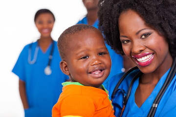 young african nurse carrying baby boy