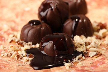 Chocolate candies with nuts, on color background