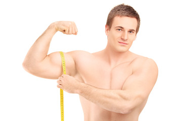 Fit shirtless guy measuring his muscle