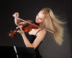 Young woman passionately playing violin - Powered by Adobe