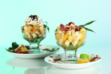 Fruit salad in a sundae dish on a blue background