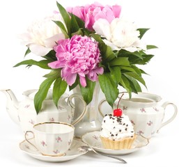 Vintage teacup with flowers and cake on white