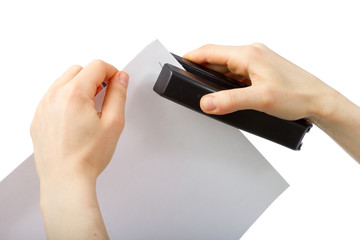Hands holding stepler and paper
